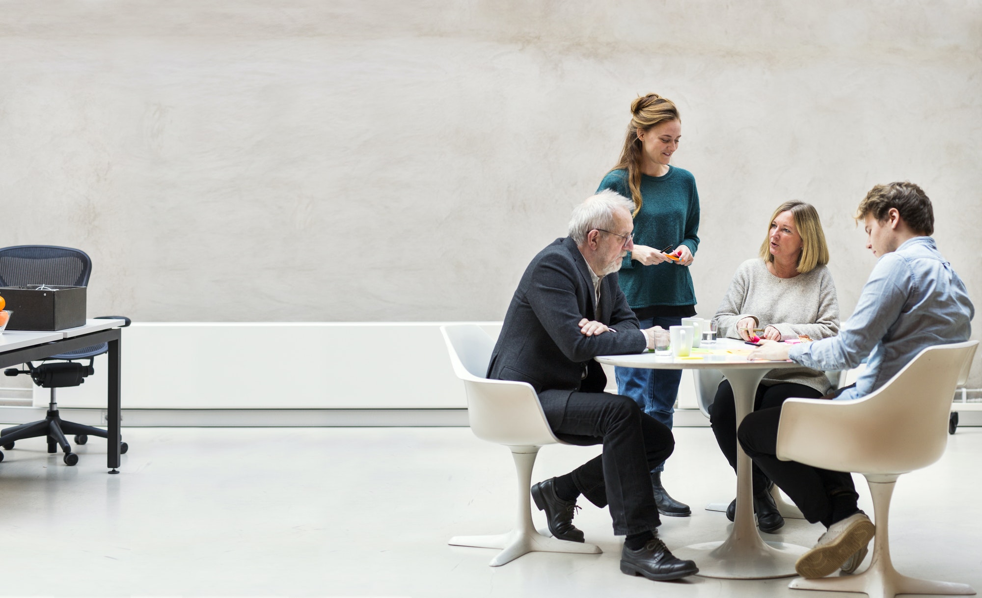Team of business people having discussion at table in creative office