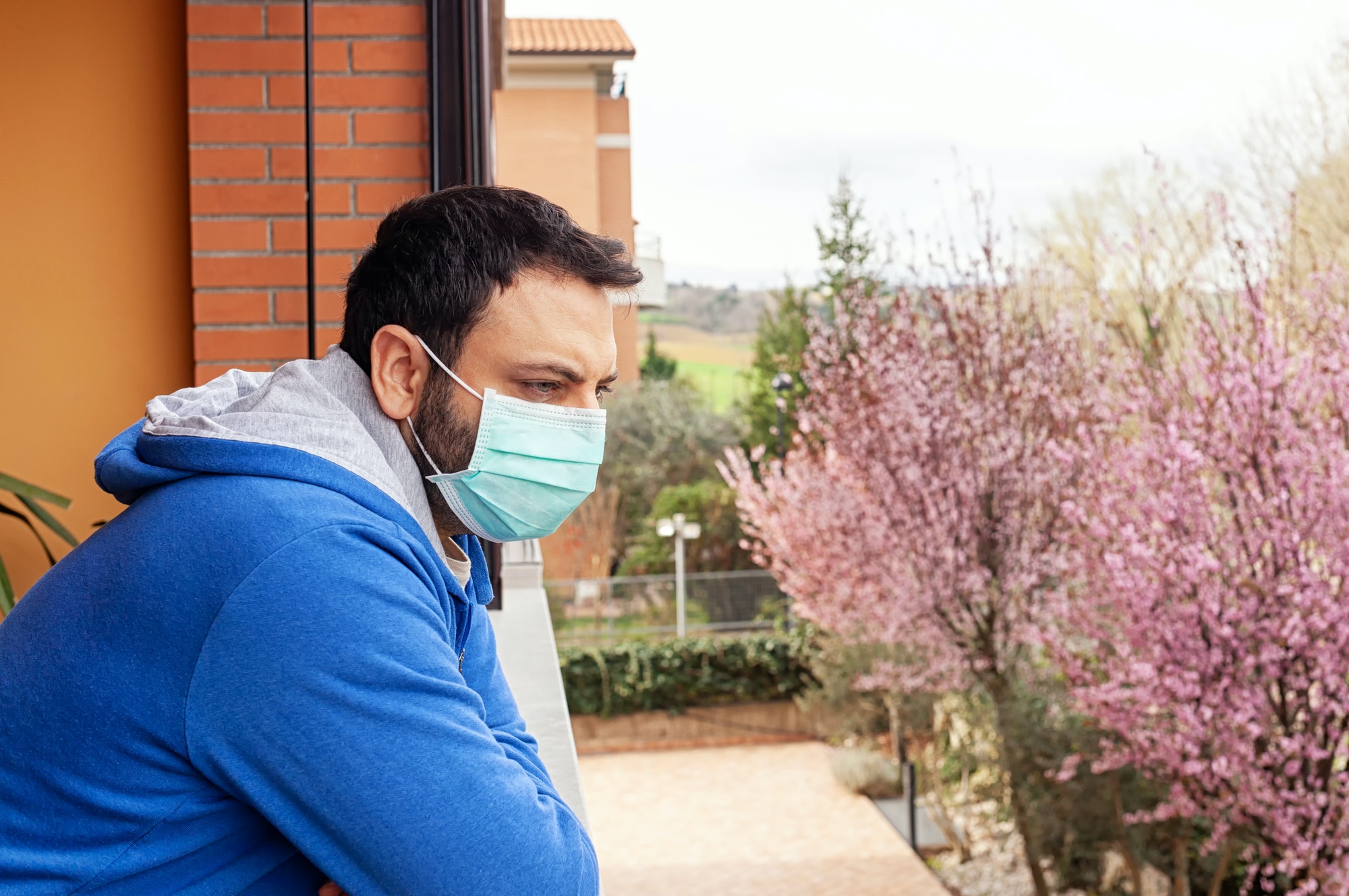 Man with mask using mobile phone during quarantine due to coronavirus