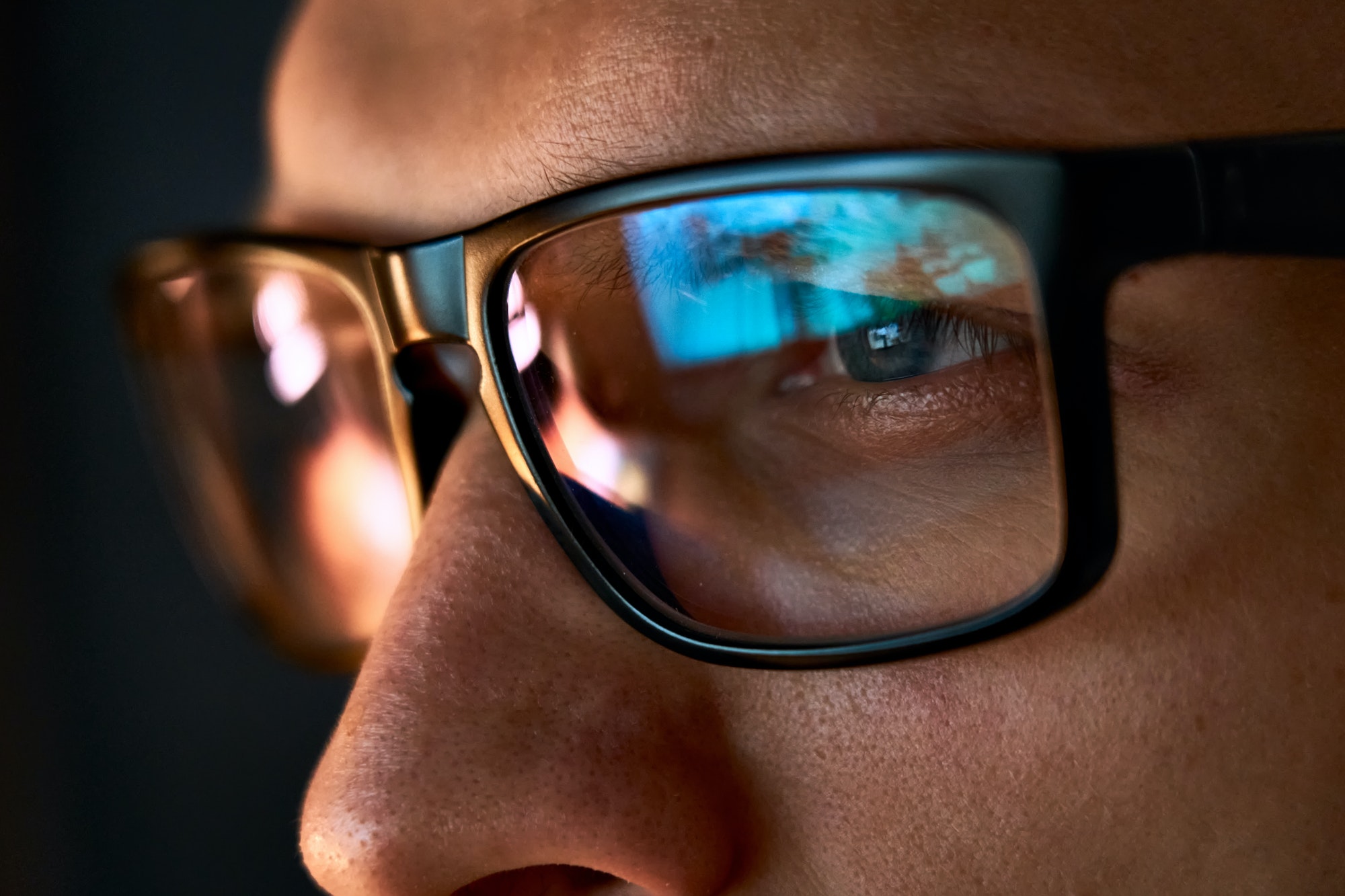 Close up view of focused businessman wear computer glasses looking at pc screen.
